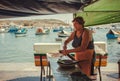 Elderly woman cutting fresh sea fish on street market of the sunny fishing town