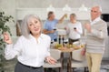 Elderly woman dancing in kitchen with friends Royalty Free Stock Photo