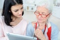 Elderly woman and daughter reading their tablet Royalty Free Stock Photo