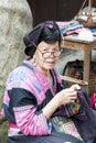 Elderly woman doeing needlework. Woman from ethnic minority Yao don`t cut hair and wear a garb with many embroidery, China Royalty Free Stock Photo