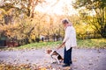 An elderly woman with dog on a walk in autumn nature. Royalty Free Stock Photo