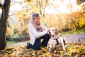 An elderly woman with dog on a walk in autumn nature. Royalty Free Stock Photo