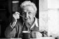 Elderly woman drinking tea sitting at the table. Royalty Free Stock Photo