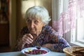 Elderly woman eating borsch soup sitting at the table Royalty Free Stock Photo