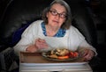 Elderly woman eating dinner