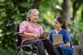 Elderly woman engaging with a nurse while using a tablet Royalty Free Stock Photo