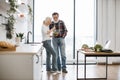 Elderly woman feeds man with healthy salad in glass bowl.