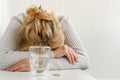 Elderly woman feeling stressed. Selective focus on glass and pills. Depression treatment