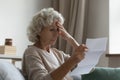 Elderly woman feels frustrated by bad news in letter Royalty Free Stock Photo