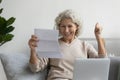 Elderly woman feels overjoyed reading great news in letter
