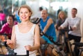 Elderly woman on fitness cycle in a gym