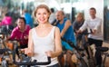 Elderly woman on fitness cycle in a gym