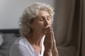 Elderly woman folding palms start new day with morning prayer Royalty Free Stock Photo