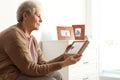 Elderly woman with framed family portrait Royalty Free Stock Photo