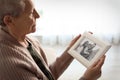 Elderly woman with framed family portrait Royalty Free Stock Photo