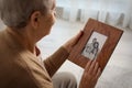 Elderly woman with framed family portrait Royalty Free Stock Photo