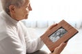 Elderly woman with framed family portrait Royalty Free Stock Photo