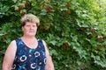 Elderly woman in a garden near Viburnum Royalty Free Stock Photo