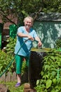 An elderly woman in the garden with water Royalty Free Stock Photo
