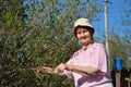 An elderly woman gardener cuts a Bush with secateurs in spring, Royalty Free Stock Photo