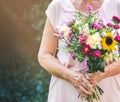 Elderly woman get a beautiful bouquet of field flowers. Senior lady holding a bunch of flowers. Royalty Free Stock Photo