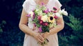 Elderly woman get a beautiful bouquet of field flowers. Senior lady holding a bunch of flowers. Royalty Free Stock Photo