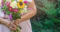 Elderly woman get a beautiful bouquet of field flowers. Senior lady holding a bunch of flowers. Royalty Free Stock Photo