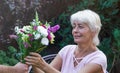 Elderly woman get a beautiful bouquet of field flowers. Royalty Free Stock Photo