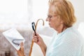 Elderly woman with glasses and loupe using a digital tablet Royalty Free Stock Photo