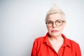 An elderly woman in glasses and in a red shirt looks sadly and involuntarily to the side Royalty Free Stock Photo