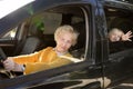 An elderly woman, grandmother or nanny, is driving a child in a car to kindergarten Royalty Free Stock Photo