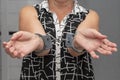 An elderly woman in handcuffs on a blurry background in an apartment. An elderly criminal, criminal liability of pensioners, domes