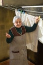 Elderly woman hanging out the washing on the terrace Royalty Free Stock Photo