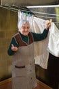 Elderly woman hanging out the washing on the terrace Royalty Free Stock Photo