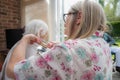 Elderly woman has hair cut by her carer during Corona virus lockdown at home Royalty Free Stock Photo