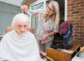 Elderly woman has hair cut by her carer during Corona virus lockdown at home Royalty Free Stock Photo