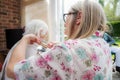 Elderly woman has hair cut by her carer during Corona virus lockdown at home Royalty Free Stock Photo