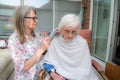 Elderly woman has hair cut by her carer during Corona virus lockdown at home Royalty Free Stock Photo