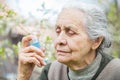 Elderly woman having asthma attack, holding a bronchodilator