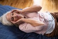 Elderly woman having a headache and touching her head with her hands at home. Royalty Free Stock Photo