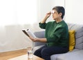 Elderly woman having troubles with long eye-sight trying to read a book. Royalty Free Stock Photo