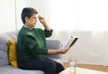 Elderly woman having troubles with long eye-sight trying to read a book. Royalty Free Stock Photo