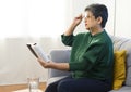 Elderly woman having troubles with long eye-sight trying to read a book. Royalty Free Stock Photo