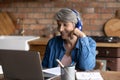 Elderly woman in headphones participate in video call conversation Royalty Free Stock Photo