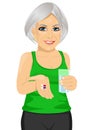 Elderly woman holding glass of water taking vitamin pills Royalty Free Stock Photo
