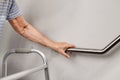 Elderly woman holding on handrail for safety steps