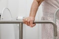 Elderly woman holding on handrail in toilet. Royalty Free Stock Photo