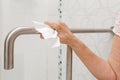 Elderly woman holding on handrail in toilet. Royalty Free Stock Photo