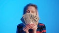 Elderly woman holding money fan in front of her face Royalty Free Stock Photo