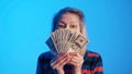 Elderly woman holding money fan in front of her face Royalty Free Stock Photo